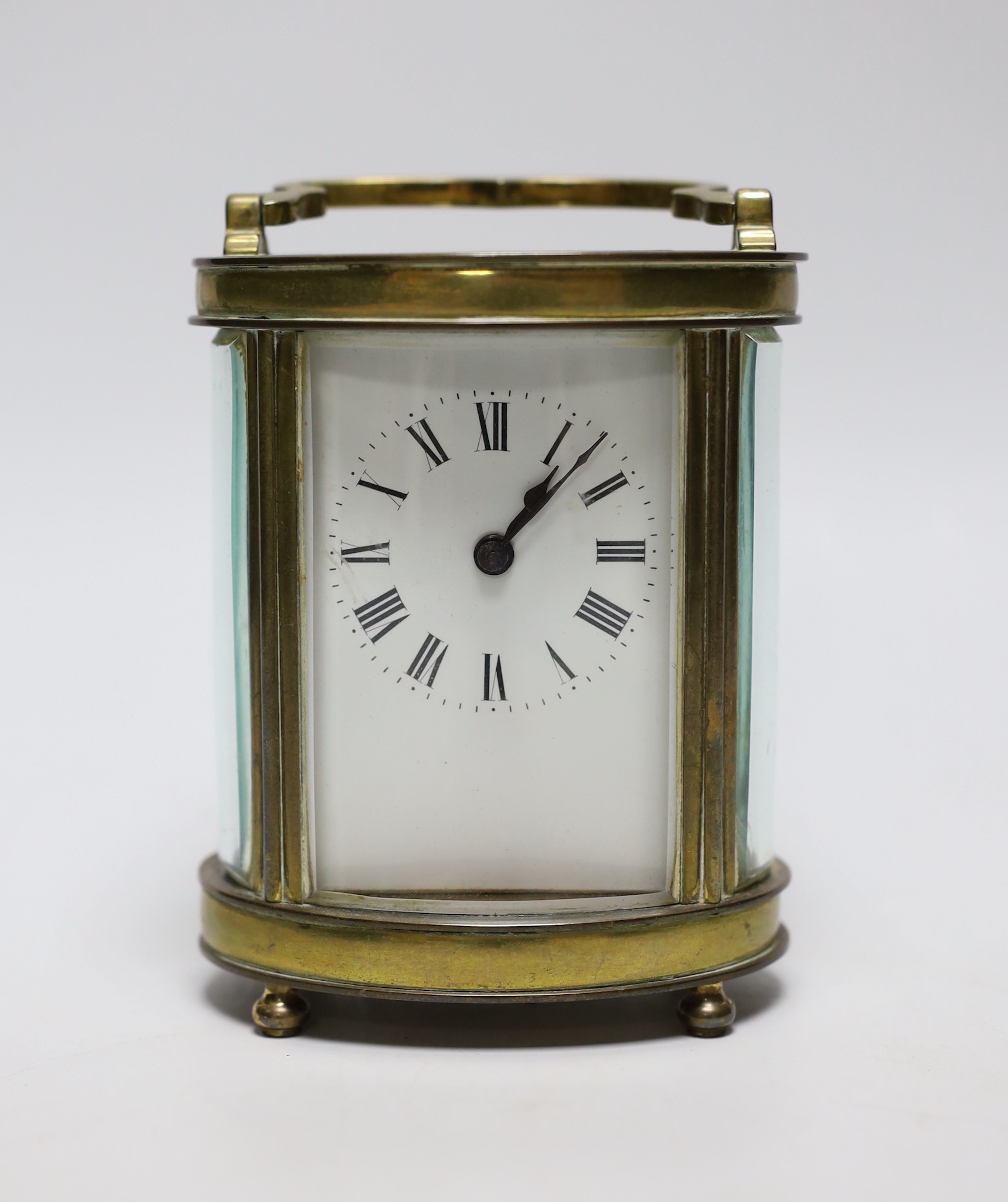 A French oval brass carriage timepiece, 11cms high